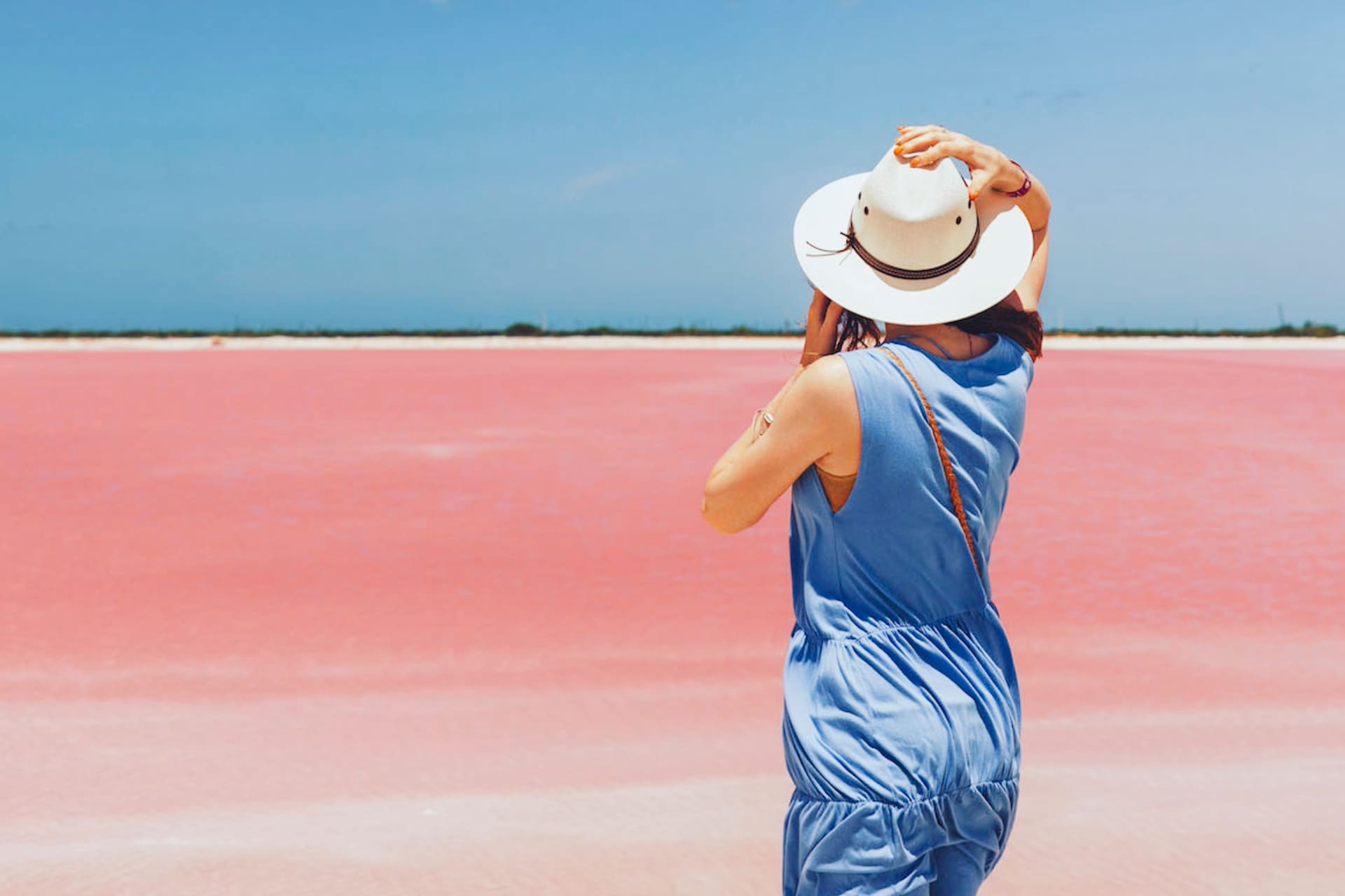 Visitante posando de espaldas en laguna rosa Las Coloradas